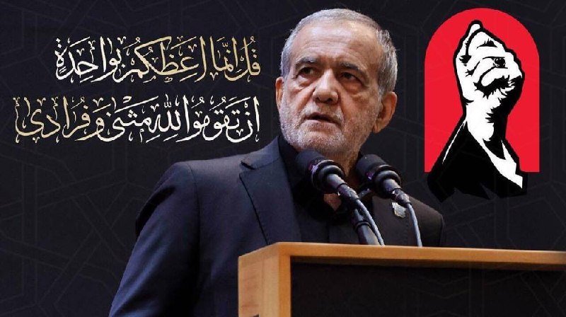 An older man with a gray beard in a dark suit speaks at a wooden podium with microphones, flanked by Arabic calligraphy and a red graphic of a raised fist.