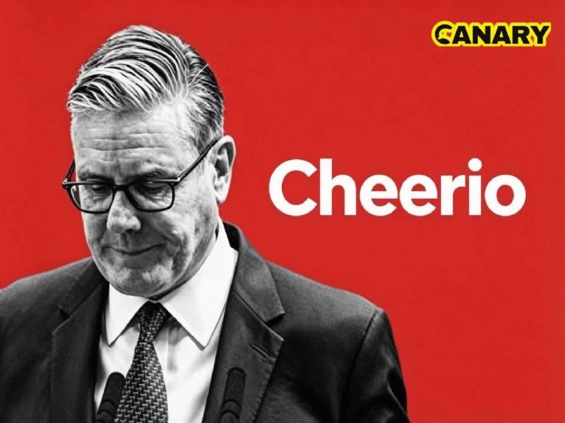 A black-and-white photo of a suited, bespectacled man looking downward stands beside the white word "Cheerio" against a solid red background, with a yellow "CANARY" logo in the top right.