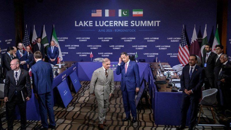 Officials and delegates gather around a conference table beneath a "Lake Lucerne Summit, June 2026, Bürgenstock" banner with US, Pakistani, and Iranian flags displayed.