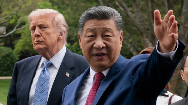 A digitally composited image shows two men in dark suits outdoors against trees: one with light hair wearing a blue striped tie, the other waving with a red tie.