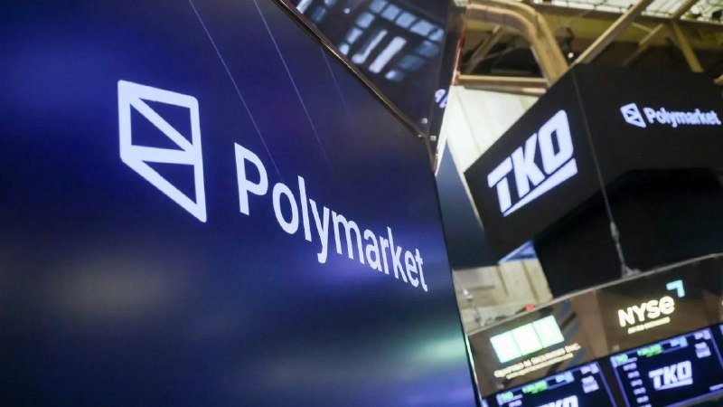 Illuminated "Polymarket" and "TKO" digital signs display alongside an "NYSE" logo on screens inside a trading floor setting.