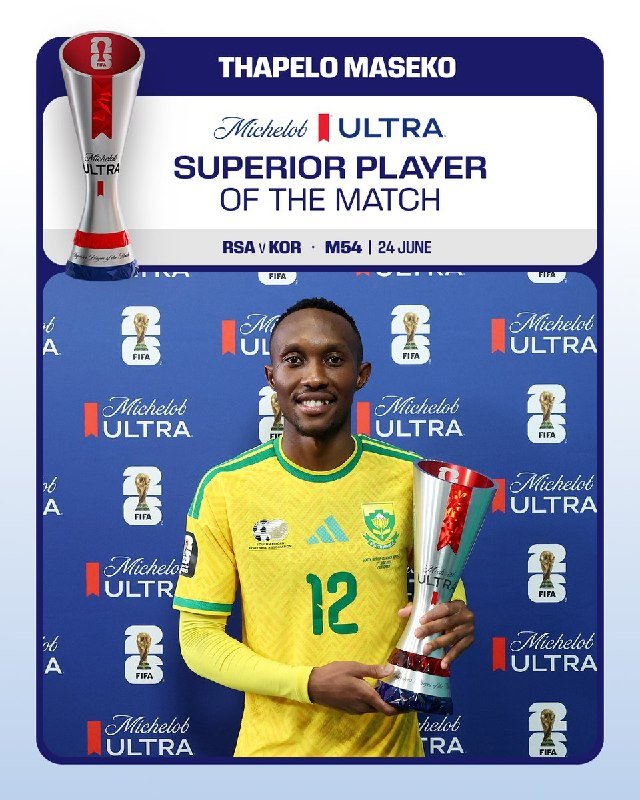 A smiling man in a yellow South Africa #12 jersey holds a Michelob Ultra "Superior Player of the Match" trophy in front of a branded backdrop.