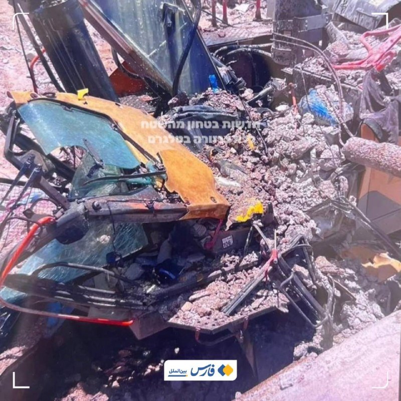 Twisted metal and shattered glass from a heavily damaged yellow vehicle lie amid rubble in an outdoor debris field.