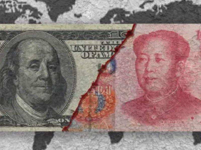 A torn US hundred-dollar bill on the left is juxtaposed against a red Chinese yuan banknote on the right, overlaid on a faded world map background.