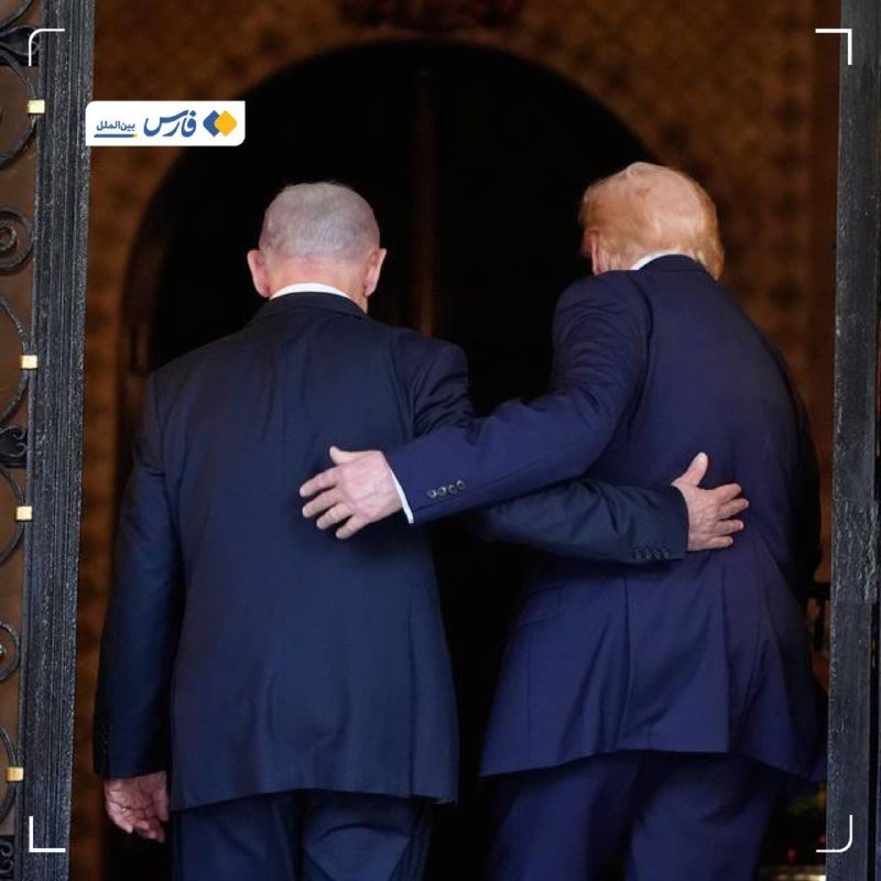 Two men in dark suits walk arm-in-arm through a stone archway into a dimly lit entrance, viewed from behind, with an Iranian news graphic overlay.