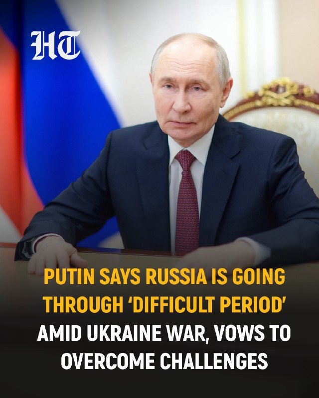 A man in a dark suit and red tie sits at a desk in front of a Russian flag, with an "HT" logo and a news headline overlay about Russia facing a difficult period.
