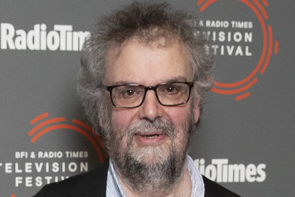 A bearded man with glasses and curly gray hair stands before a backdrop featuring "Radio Times" and "BFI & Radio Times Television Festival" logos.