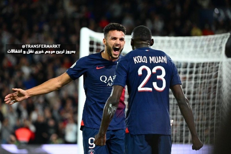 Two soccer players in dark blue "QATAR AIRWAYS" jerseys celebrate near a goal, with one shouting joyfully and the other, wearing "KOLO MUANI 23," facing away amid a blurred stadium crowd.