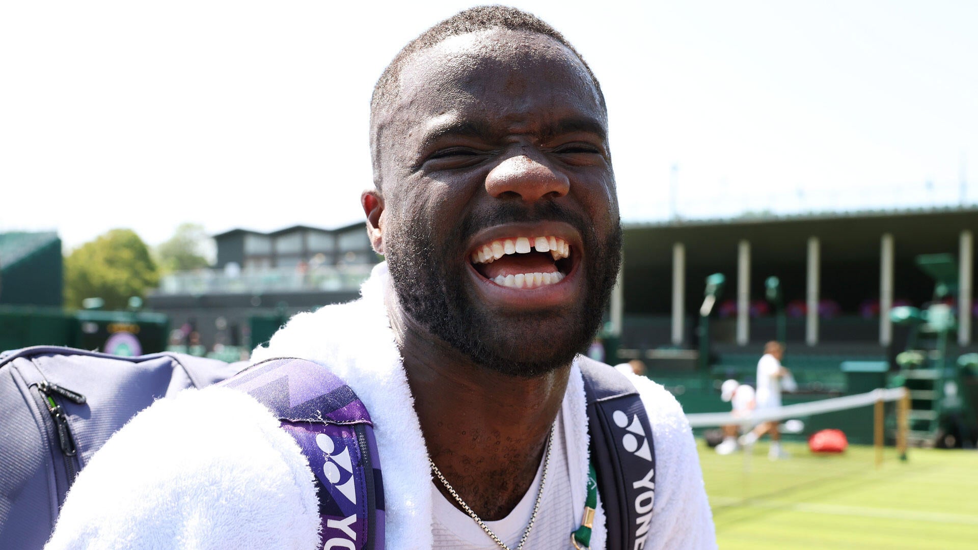 Frances Tiafoe smiles during a previous grass-court event in England — Wimbledon 2026 begins this week amid talk of fresh upsets.