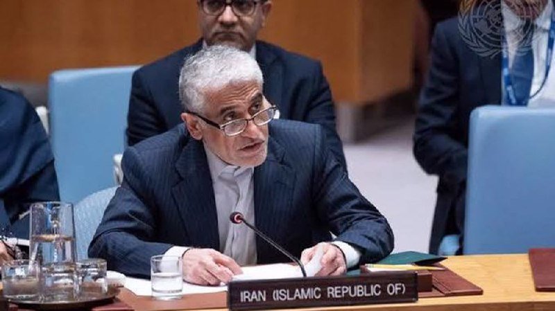A man with grey hair and glasses speaks at a desk labeled "IRAN (ISLAMIC REPUBLIC OF)" with a UN emblem visible behind him.