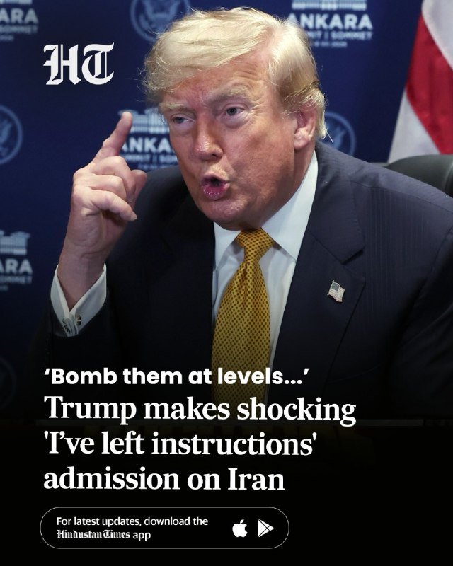 A man with blonde hair in a dark suit and gold tie points his finger while speaking, with an American flag and "ANKARA" backdrop visible behind him.