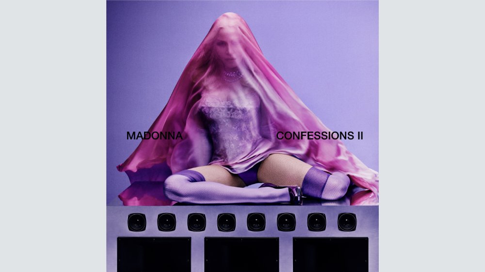 Album cover showing a seated figure in corset, fishnet stockings, and pink veil, with "MADONNA" and "CONFESSIONS II" text against a purple backdrop.