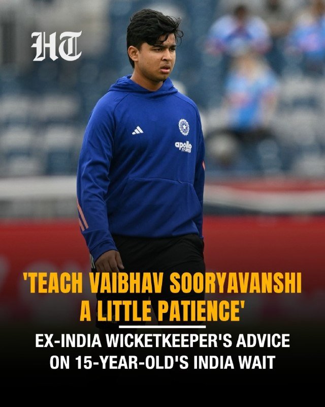 A young man in a blue Adidas hoodie stands in a stadium with text overlay reading "'TEACH VAIBHAV SOORYAVANSHI A LITTLE PATIENCE' — EX-INDIA WICKETKEEPER'S ADVICE ON 15-YEAR-OLD'S INDIA WAIT."