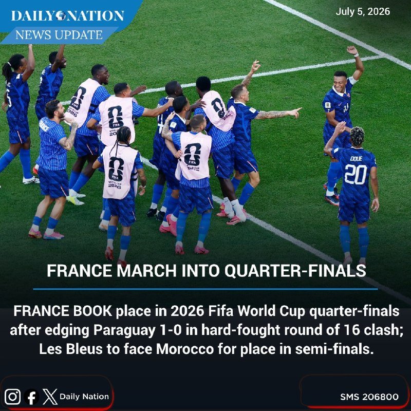 A French national football team celebrates on the pitch, with players in blue kits clustering together and a player wearing "DOUÉ 20" running toward them.