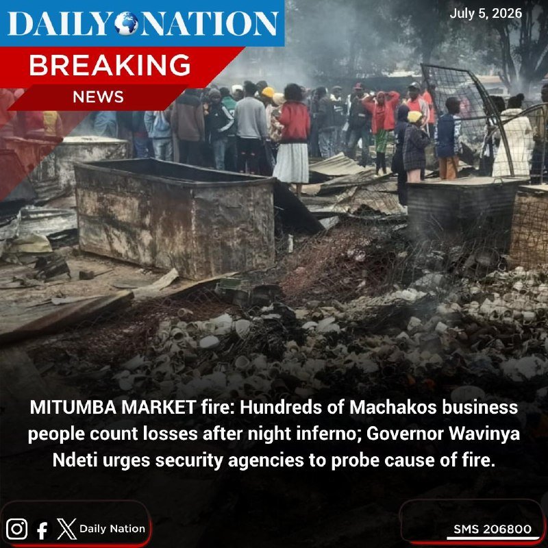 A crowd gathers near charred debris and a burned metal container amid smoke at an outdoor market, as shown in a Daily Nation breaking news graphic dated July 5, 2026.