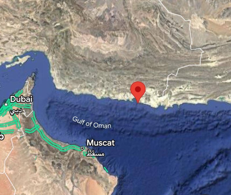 A satellite map displays the Gulf of Oman, with a red pin marking a coastal location near labeled cities of Dubai and Muscat.