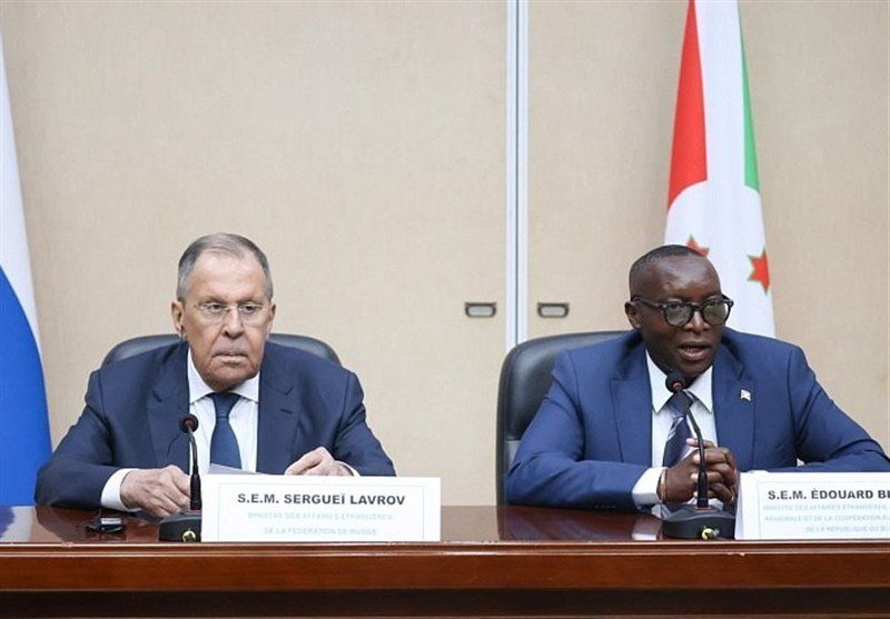 Two men in suits sit at a table with microphones and nameplates reading "S.E.M. SERGUEI LAVROV" and "S.E.M. ÉDOUARD B..." during an official meeting.