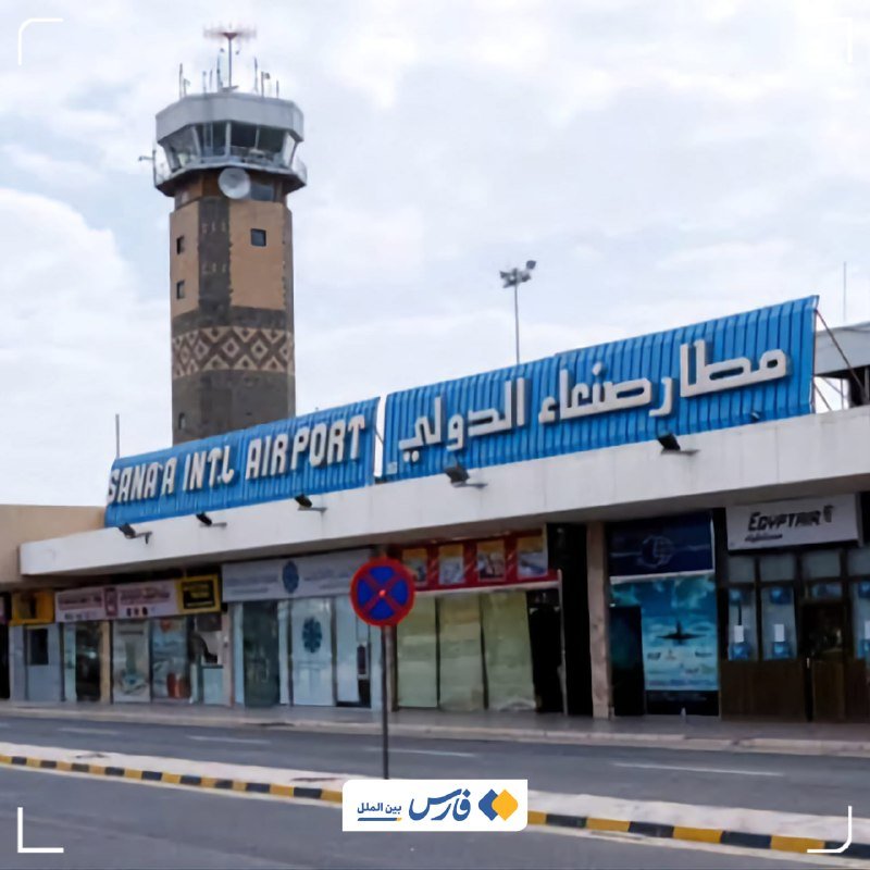 The Sana'a International Airport terminal, with its blue Arabic and English signage, stands closed under cloudy skies beside a tall patterned control tower.