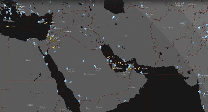 A dark-themed map of the Middle East displays yellow airplane and star icons clustered over Syria, Lebanon, Israel, Iraq, Iran, and the United Arab Emirates, alongside blue location markers.