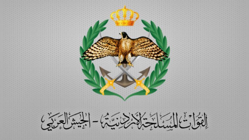 A graphic emblem featuring a golden eagle with outstretched wings, a crown above, crossed swords behind, and a green laurel wreath, accompanied by Arabic text below.