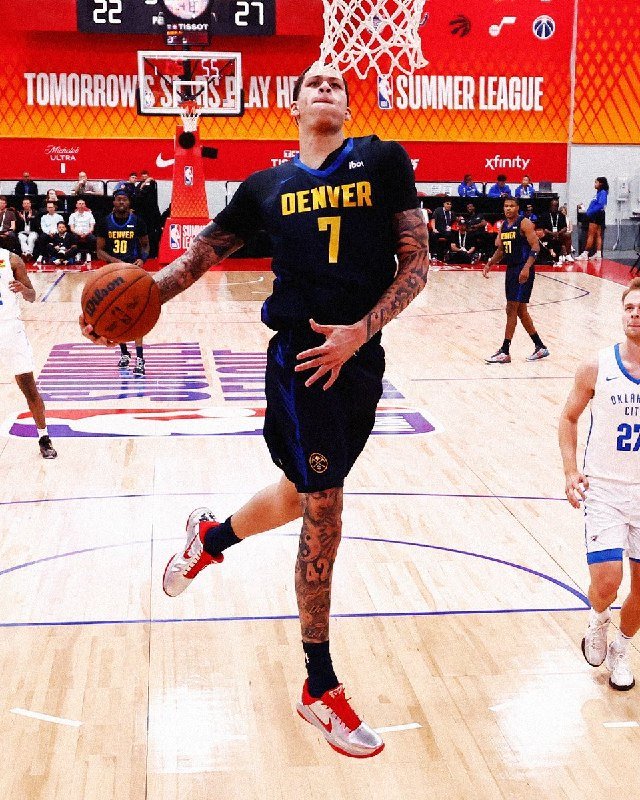 A tattooed Denver basketball player wearing jersey number 7 leaps toward the hoop with the ball during a Summer League game at Tissot.