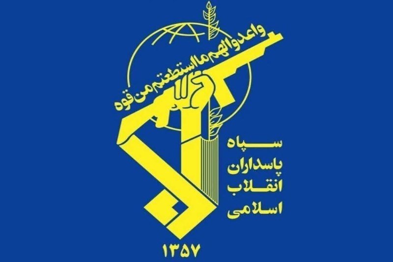 A blue and gold emblem features an AK-47, a raised fist, Arabic script, a globe with an olive branch, and the year 1357.