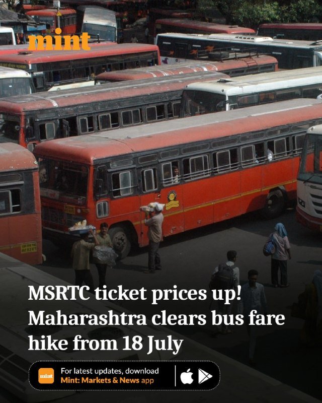 A crowded bus stand shows several red and white buses parked closely together while passengers and vendors walk alongside them carrying bags.