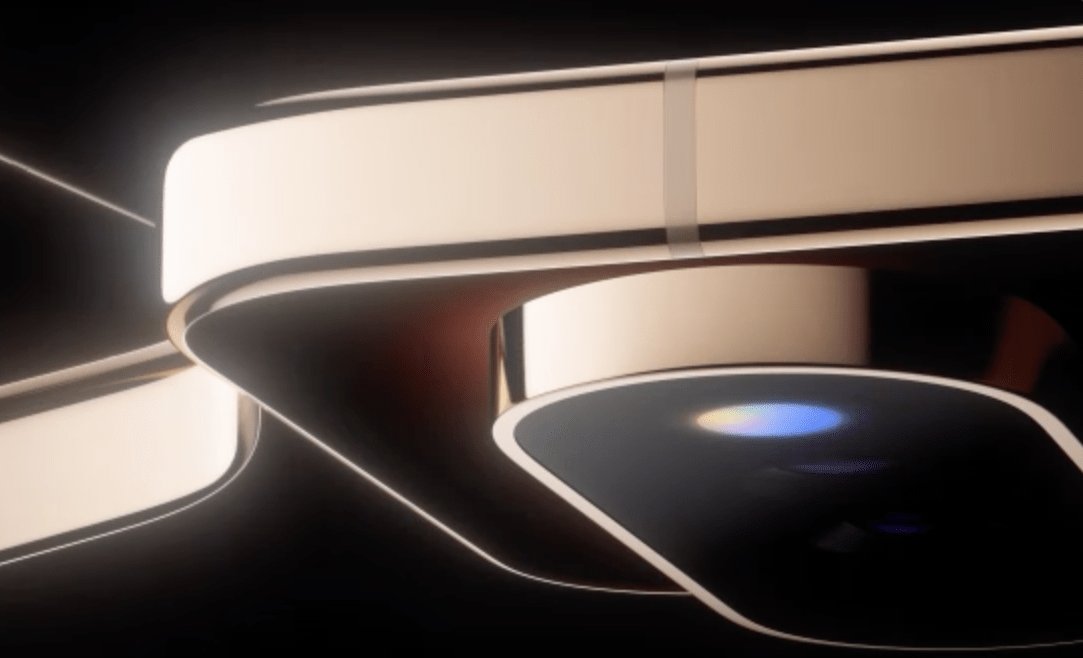 Close-up product photograph showing a curved, illuminated light strip wrapping around a metallic device with a dark camera lens module below.