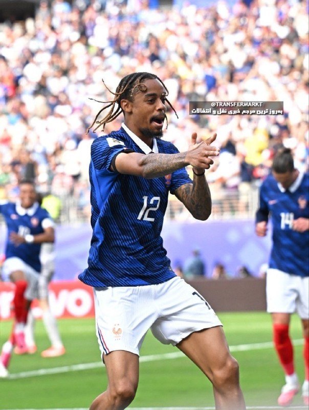 A soccer player wearing a blue jersey with the number 12 and white shorts celebrates on a field, with teammates and a crowded stadium visible in the background.